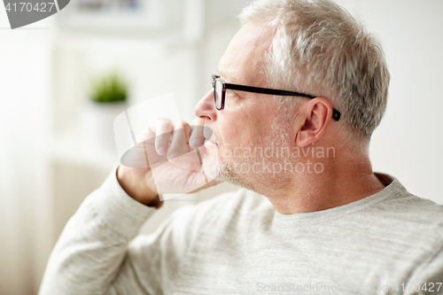 Image of close up of senior man in glasses thinking