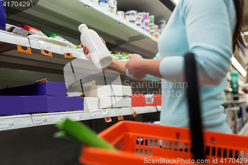 Image of woman with milk bottle at grocery or supermarket