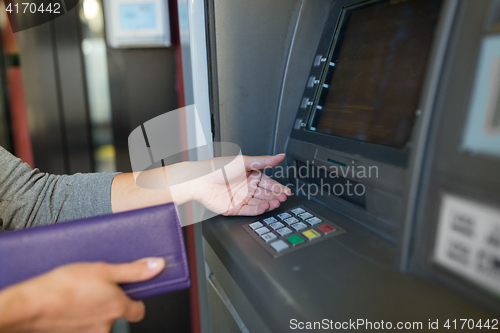 Image of close up of hands withdrawing cash at atm machine