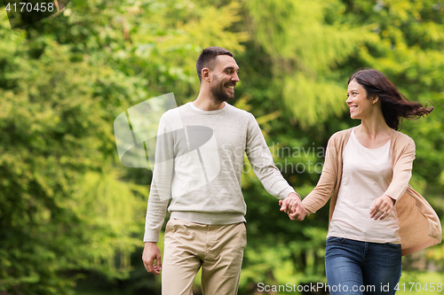 Image of happy couple walking in summer park