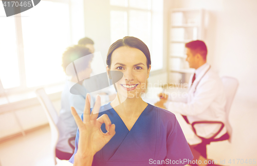 Image of happy doctor over group of medics at hospital