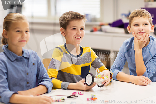 Image of happy children building robots at robotics school