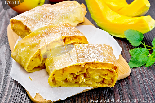 Image of Strudel pumpkin and apple on dark wooden board