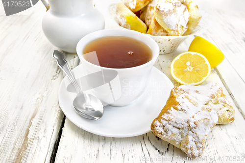 Image of Tea in white cup with lemon cookies on board