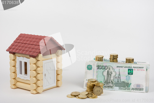 Image of Near the toy house is a lot of money on buying a home, white background