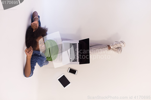 Image of african american woman sitting on floor with laptop top view