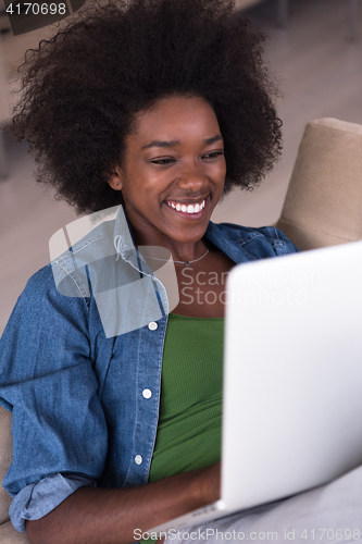 Image of African American women at home in the chair using a laptop