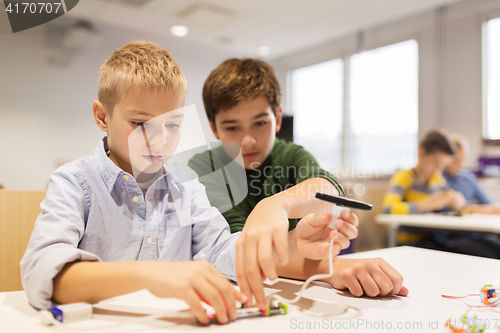 Image of happy children building robots at robotics school