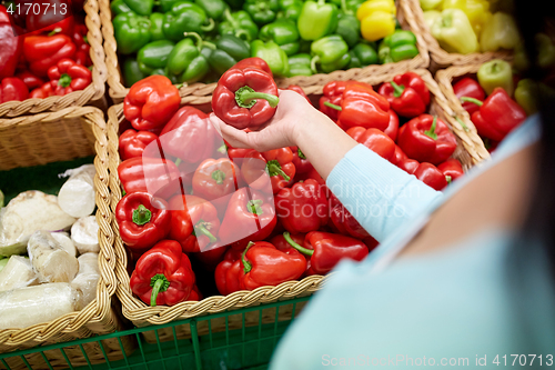 Image of woman with basket buying peppers at grocery store