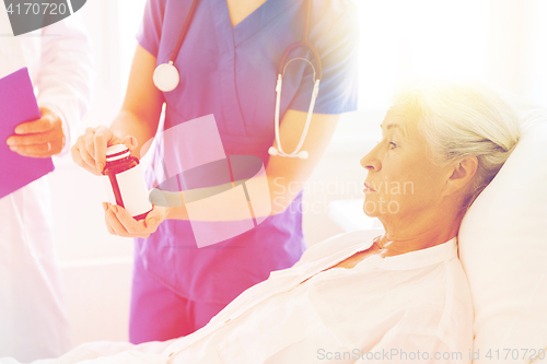 Image of doctor giving medicine to senior woman at hospital