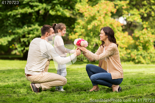 Image of happy family with flowers in summer park