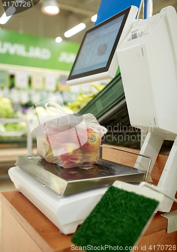 Image of apples in plastic bag on scale at grocery store