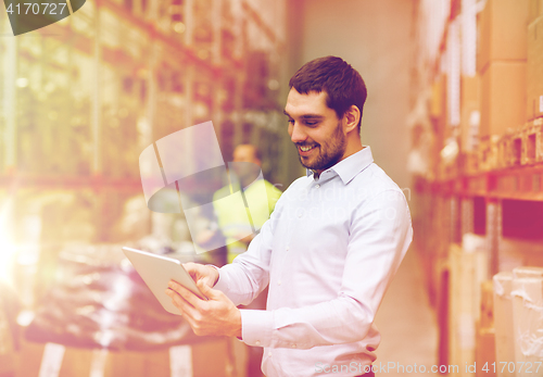 Image of happy businessman with clipboard at warehouse