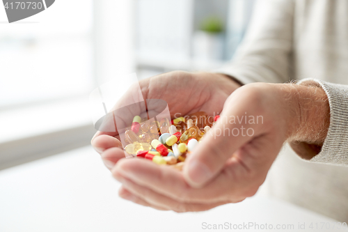 Image of close up of old man hands holding medicine