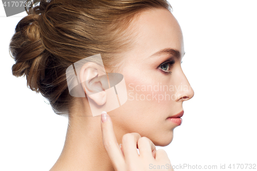 Image of beautiful woman pointing finger to her ear