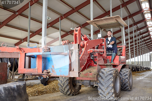 Image of man or farmer driving tractor at farm