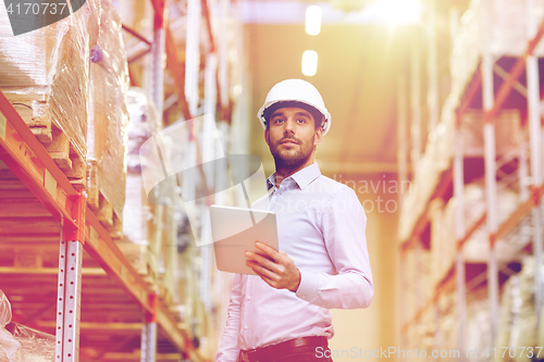 Image of happy businessman with tablet pc at warehouse