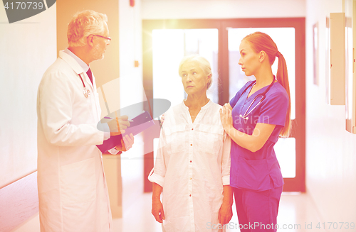 Image of medics and senior patient woman at hospital