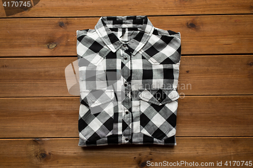 Image of checkered shirt on wooden background