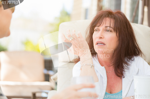 Image of Two Female Friends Enjoying Conversation Outside