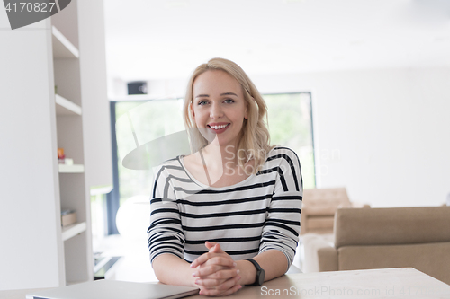 Image of Young woman with laptop at home