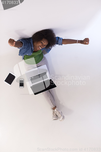 Image of african american woman sitting on floor with laptop top view