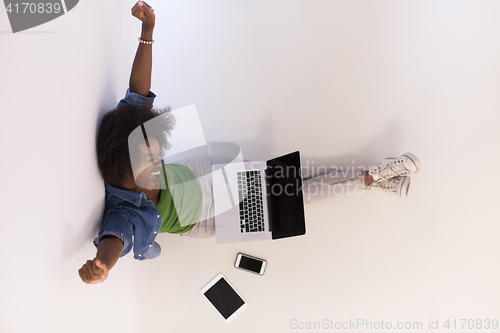 Image of african american woman sitting on floor with laptop top view