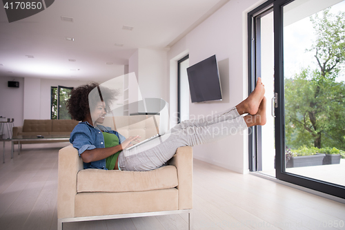 Image of African American women at home in the chair using a laptop