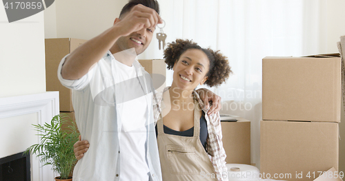 Image of Smiling young man holding the keys to a new home