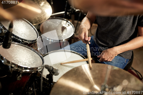 Image of male musician playing drums and cymbals at concert