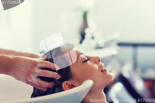 Image of happy young woman at hair salon