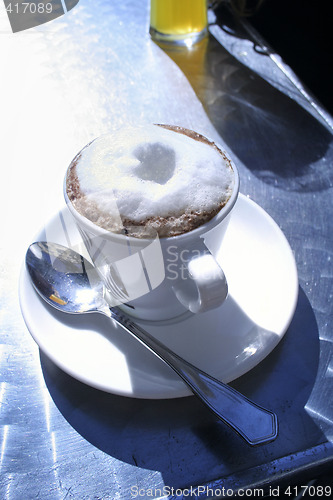 Image of Cappuccino on sunny table