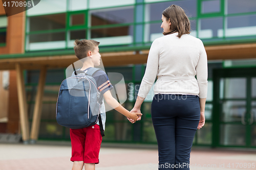 Image of elementary student boy with mother at school yard