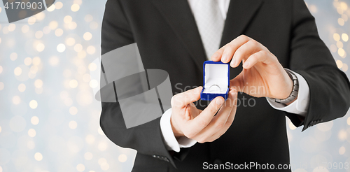 Image of close up of man with engagement ring in gift box