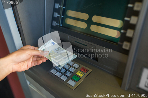 Image of close up of hand withdrawing money at atm machine