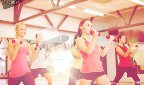 Image of group of smiling people working out with dumbbells