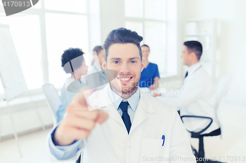 Image of happy doctor over group of medics at hospital