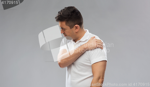 Image of unhappy man suffering from pain in shoulder