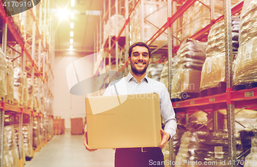 Image of happy man with cardboard parcel box at warehouse