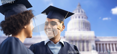 Image of happy students or bachelors in mortar boards