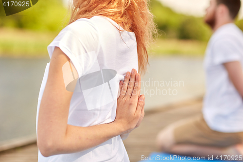 Image of group of people making yoga exercises outdoors