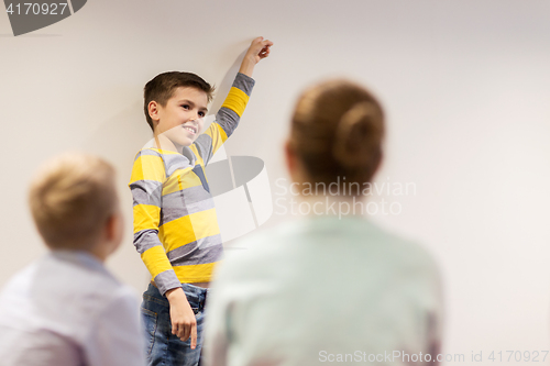 Image of student boy with marker writing on flip board