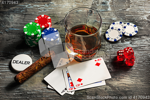 Image of Cigar, chips for gamblings, drink and playing cards