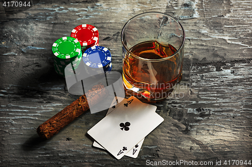 Image of Cigar, chips for gamblings, drink and playing cards