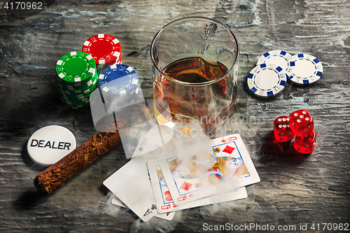 Image of Cigar, chips for gamblings, drink and playing cards