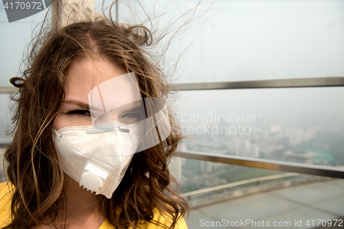 Image of Woman in medical mask against the air pollution