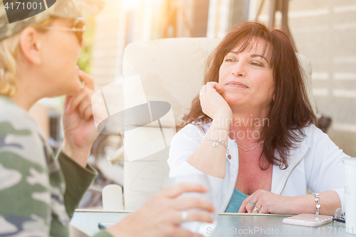 Image of Two Female Friends Enjoying Conversation Outside