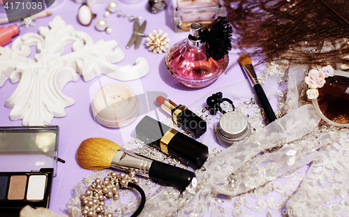 Image of Jewelry table with lot of girl stuff on it, little mess in cosmetic brushes, women interior concept, perfume elegance things, little princess makeup