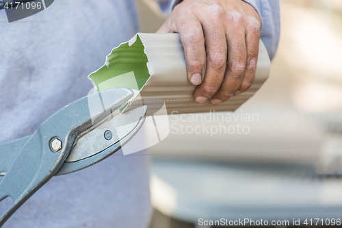 Image of Worker Cutting Aluminum Rain Gutter With Heavy Shears