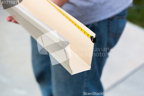 Image of Worker Measuring Rain Gutter Processing Through Seamless Shaping